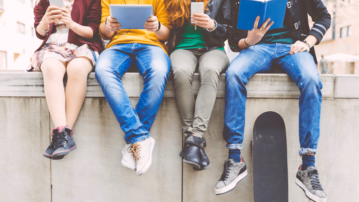 Jóvenes con libros y dispositivos
